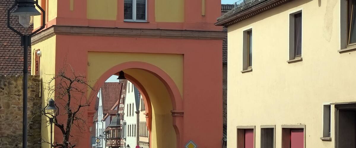 A yellow building with a clock tower and an archway.