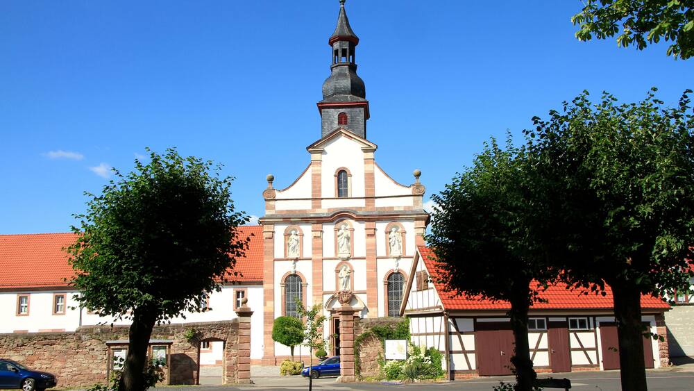 Une église dotée d’un clocher élevé et d’un toit rouge.