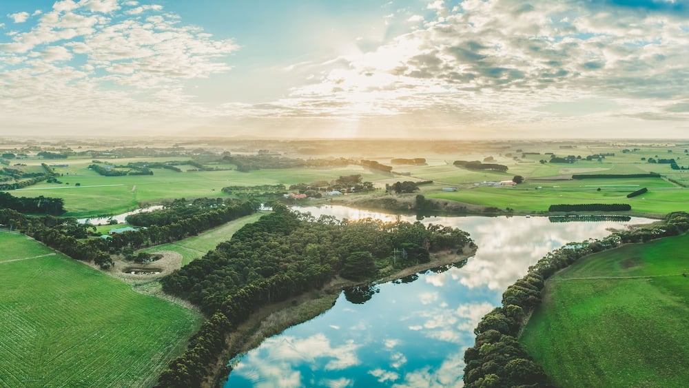 Wide aerial panorama of sunset over Hopkins River and grasslands in Warrnambool, Australia
