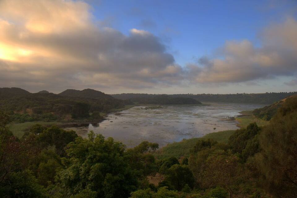 A river meandering through a lush valley with hills in the background.