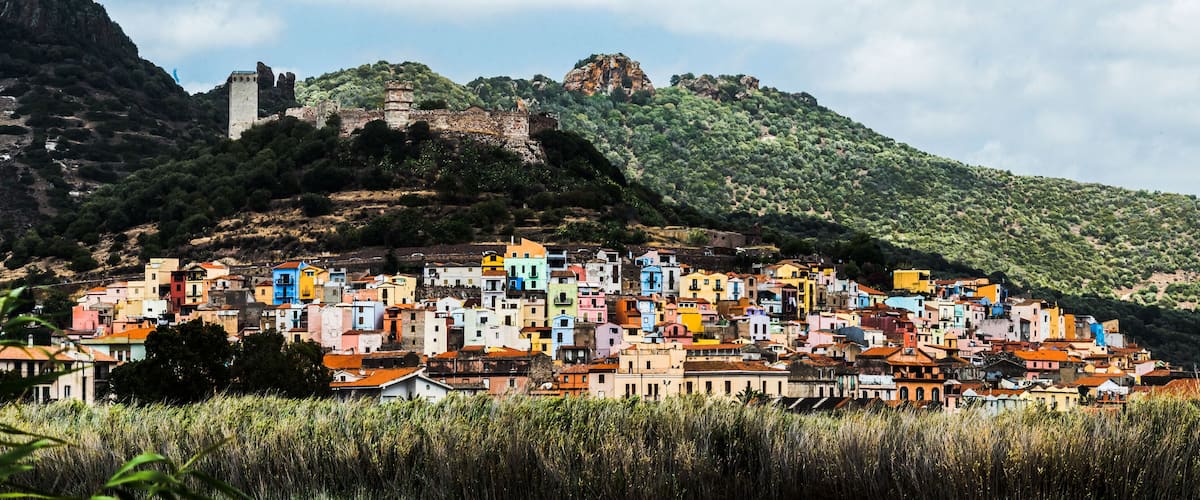 A colorful hillside town with a historic castle on a hill.