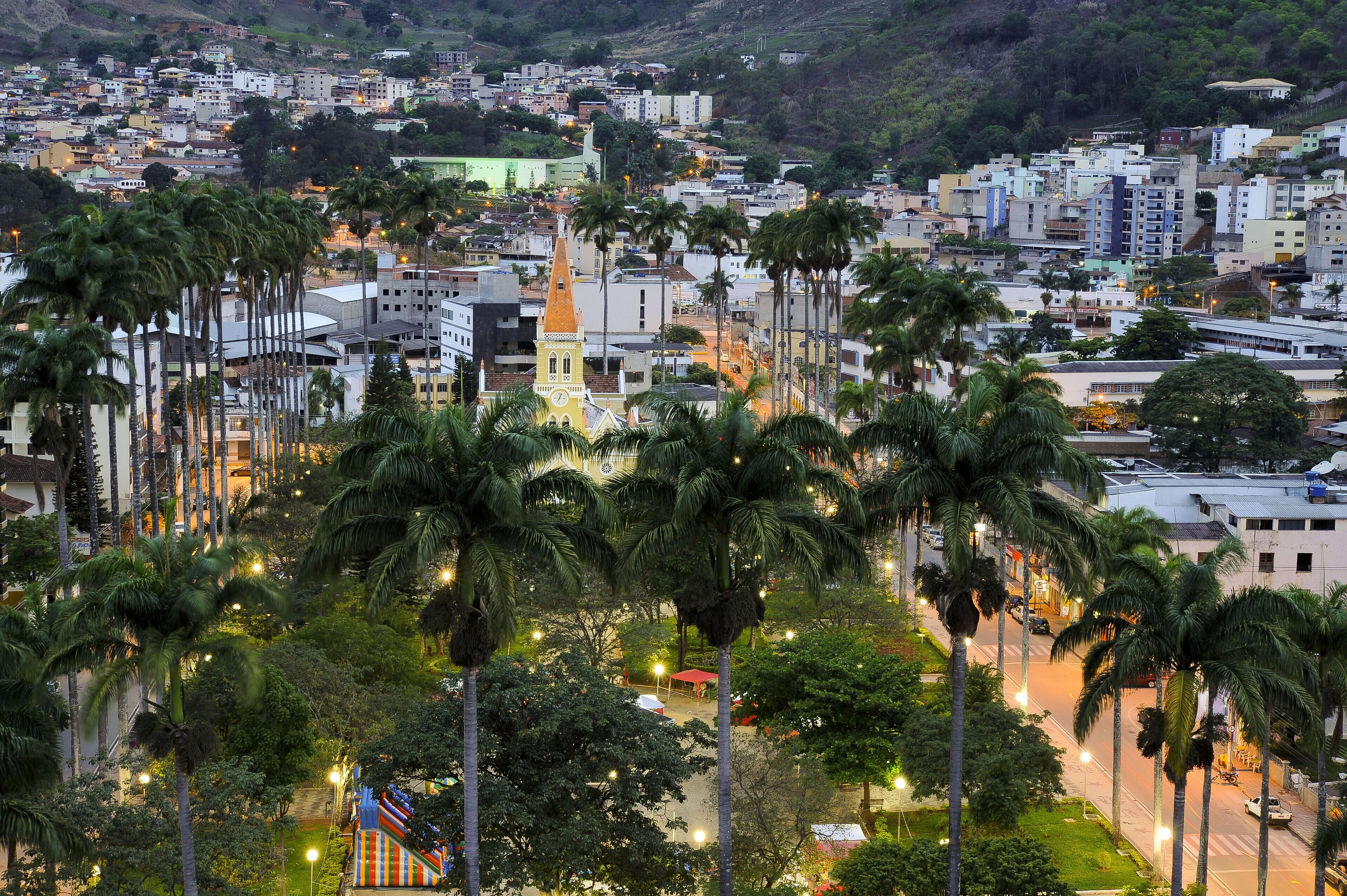 A cityscape with a prominent church steeple, palm trees, and residential buildings.