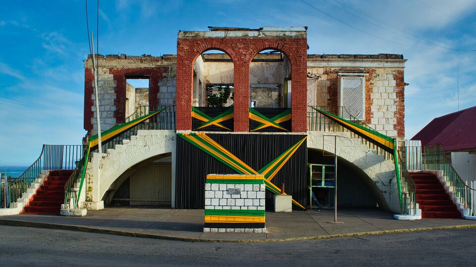 An old building with a staircase and a mural.