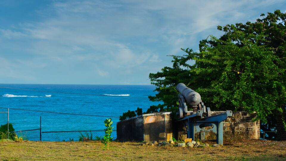 A cannon on a platform overlooking the ocean.