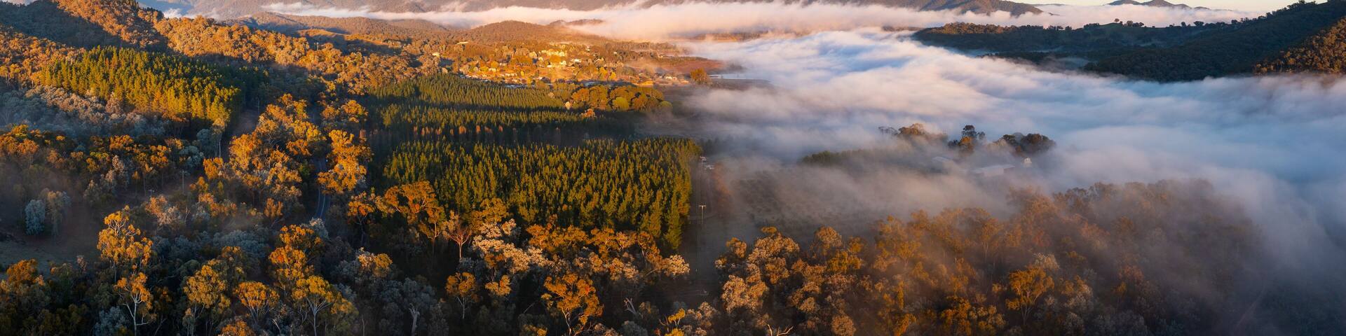 Aerial panorama of fog filling a valley below a distant mountain range