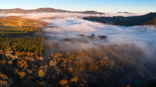 Aerial panorama of fog filling a valley below a distant mountain range
