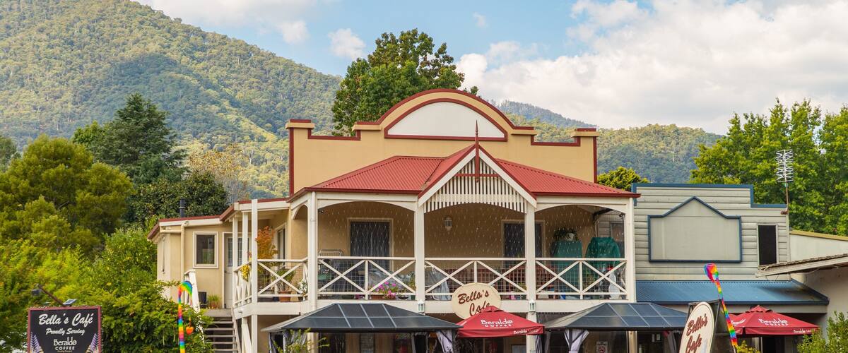 Bella's Café with outdoor seating and a mountain backdrop.