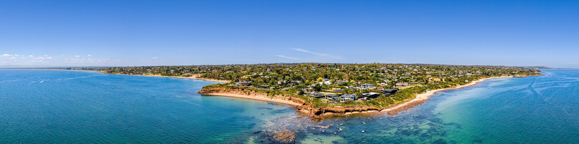 Aerial shot of Daveys Bay Pelican Point, Mount Eliza coastal seascape with turquoise sea and clear blue sky aerial panoramic
