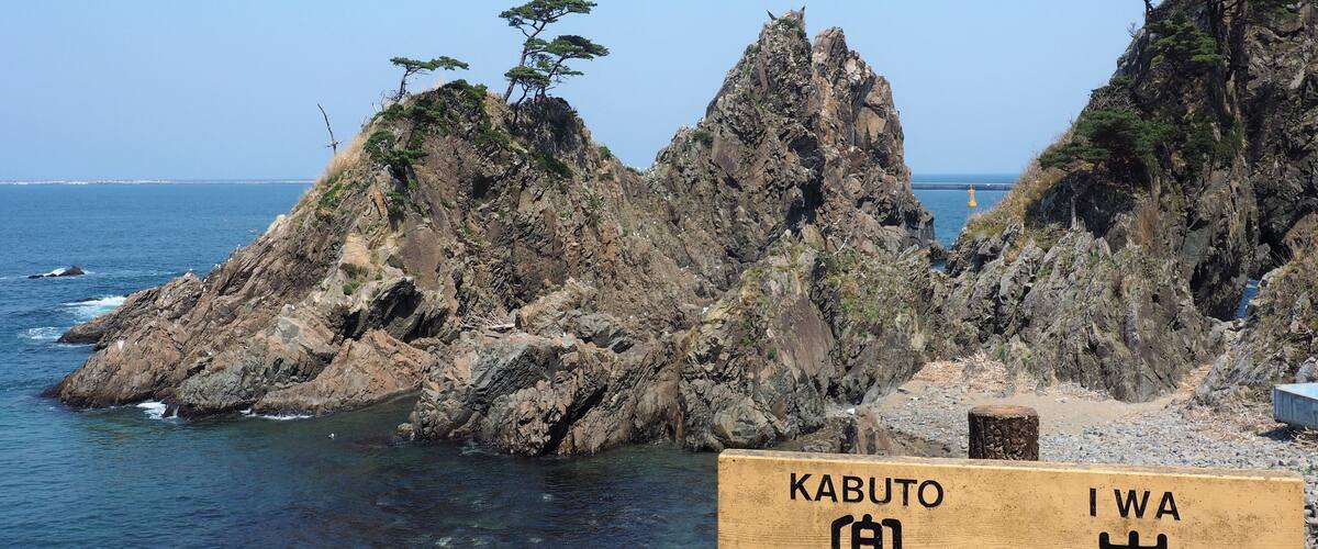 A rocky coastline with a sign reading "KABUTO IWA".