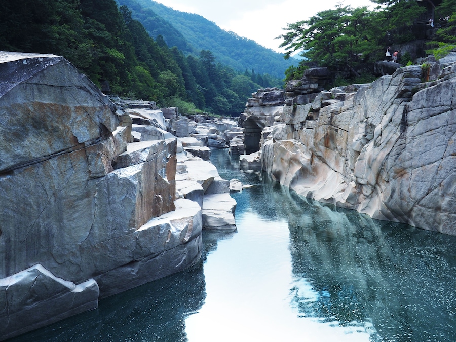 Une rivière qui traverse un défilé rocheux, avec de gros blocs de pierre de chaque côté.