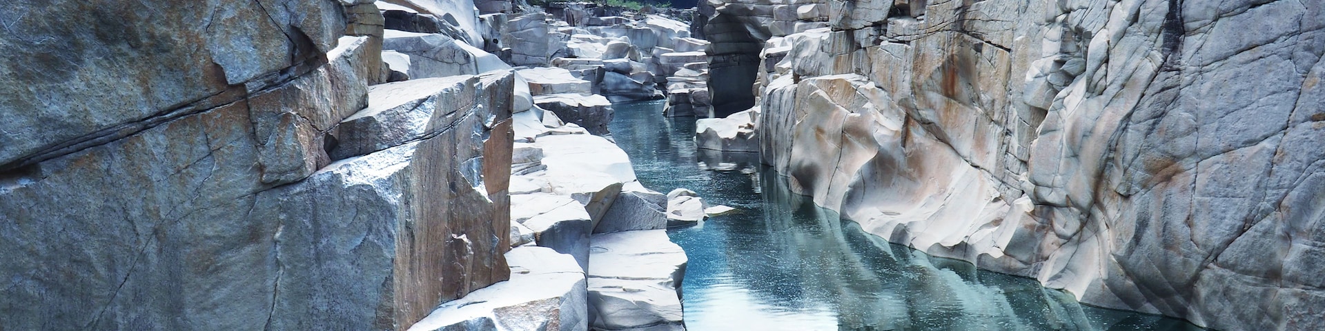 Un río que serpentea por un desfiladero rocoso con grandes rocas a ambos lados.