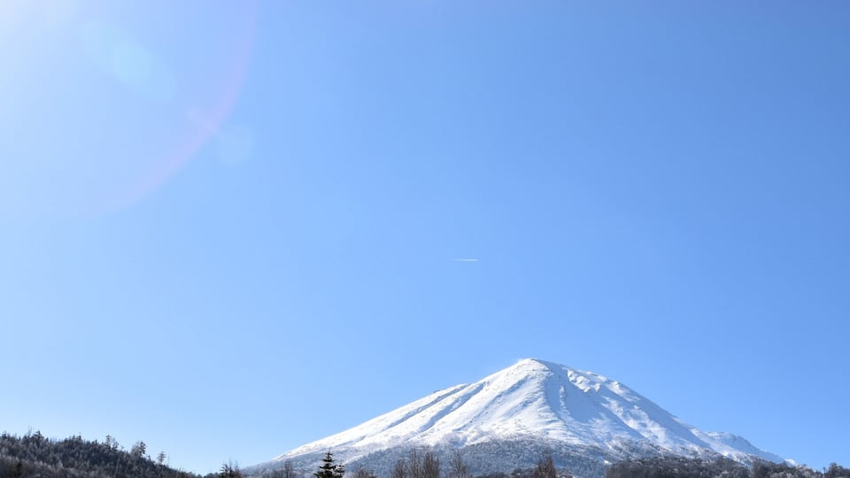 A snow-covered mountain under a clear blue sky.