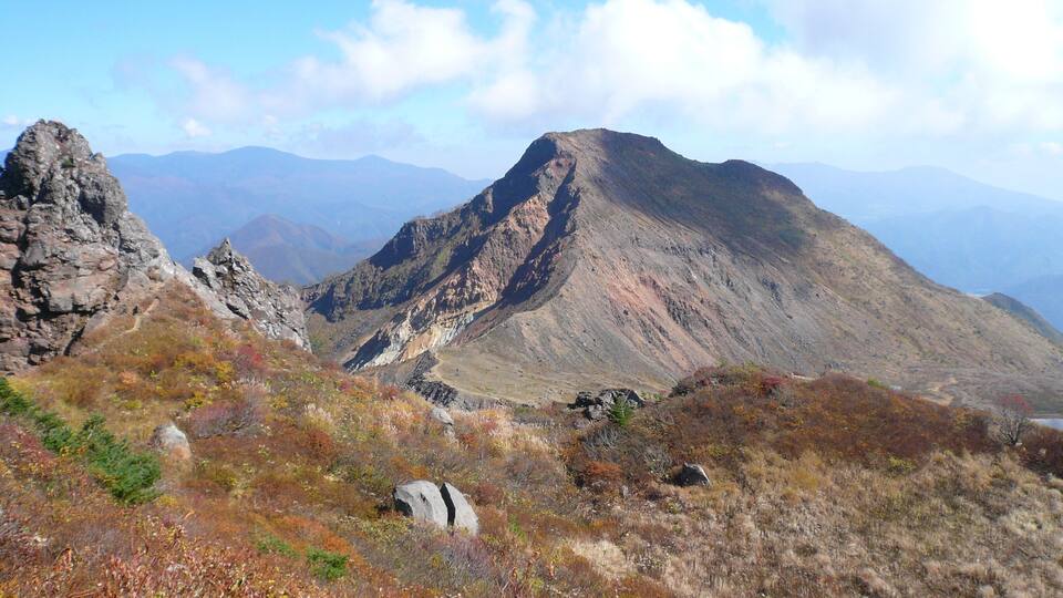 A rugged mountain landscape with rocky outcrops and sparse vegetation.