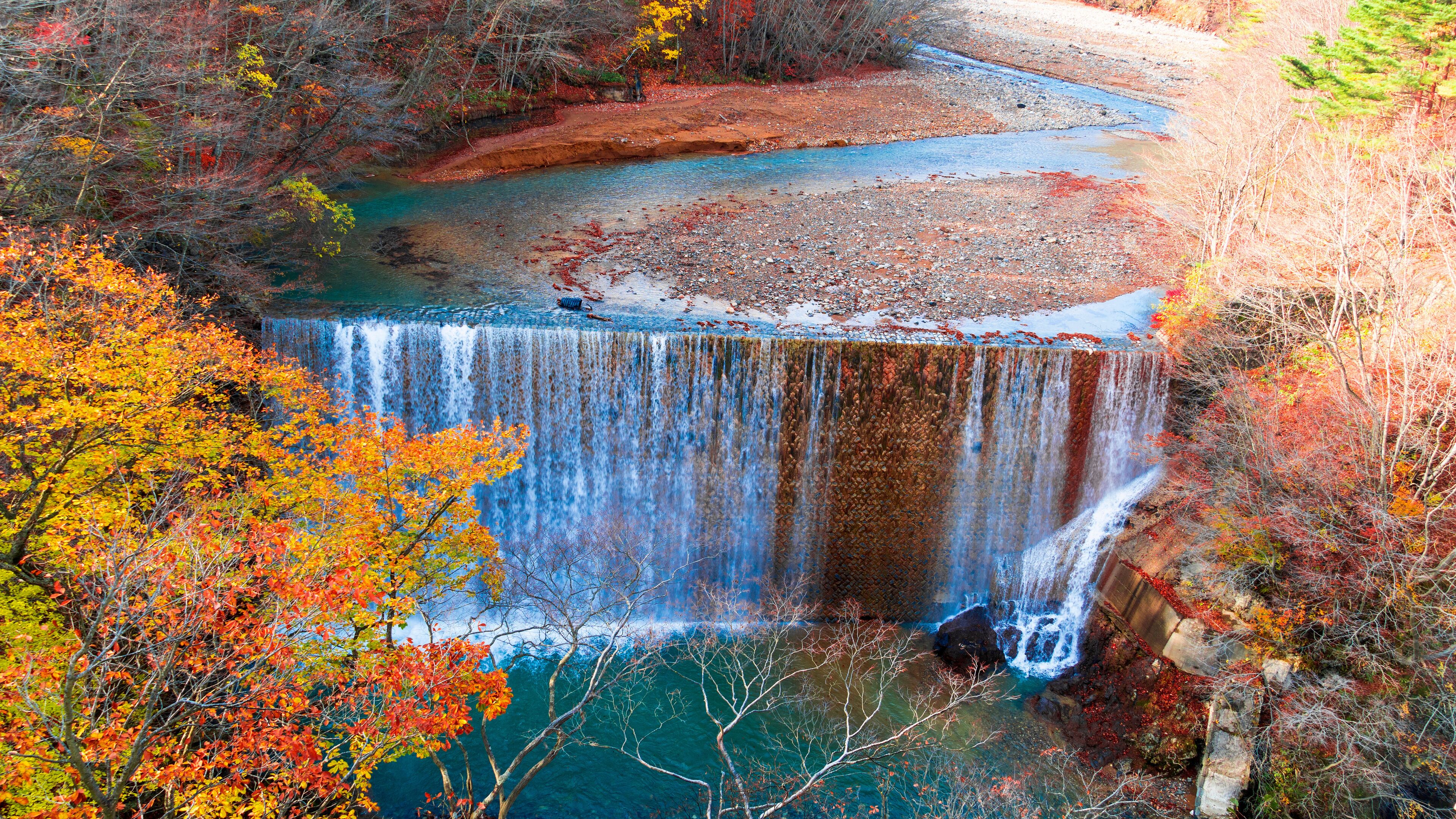 A waterfall surrounded by autumn foliage.