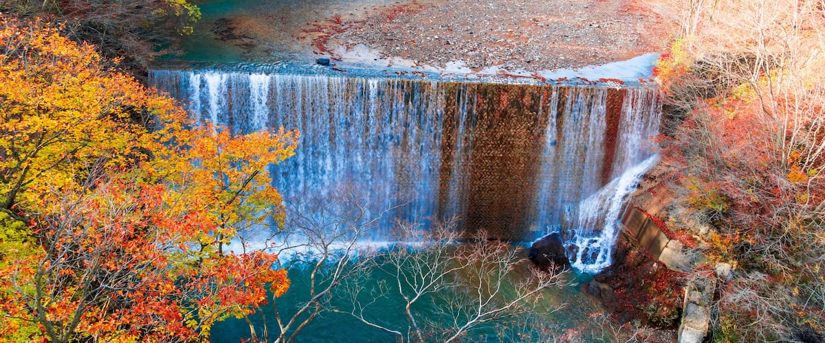 Una cascada rodeada de follaje otoñal.