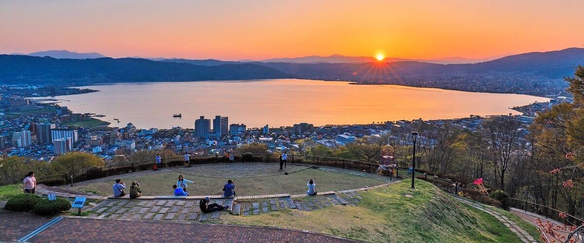 A sunset over a lake with a cityscape in the background.