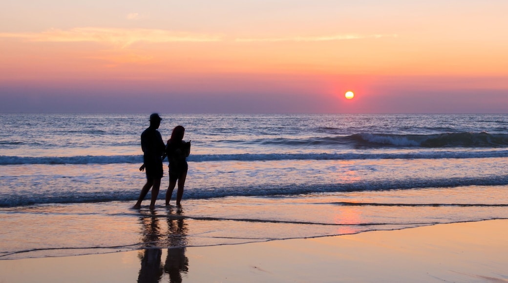 Silhouettes of a couple enjoying the sunset on the atlantic ocean, Lacanau France