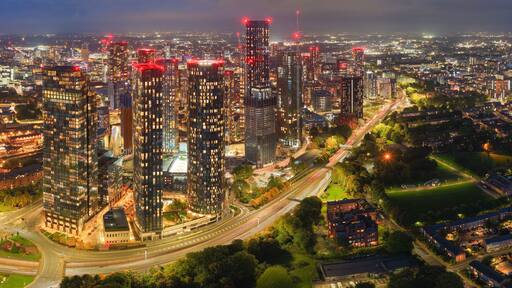 Striking long-exposure night panorama of Manchester skyline with glowing city lights and traffic along Mancunian Way.