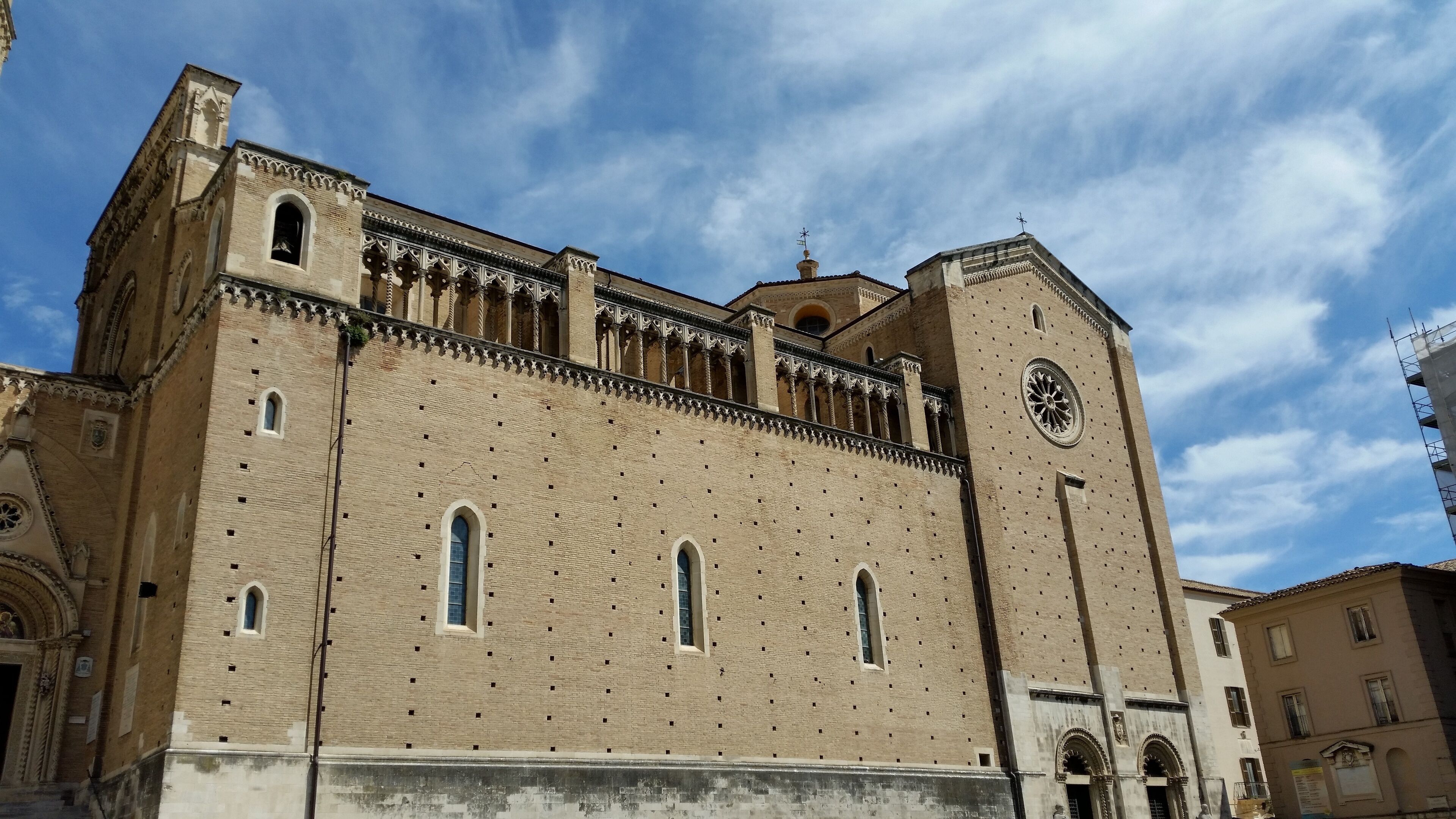A large, historic building with intricate architectural details, including arched windows and a prominent clock tower.