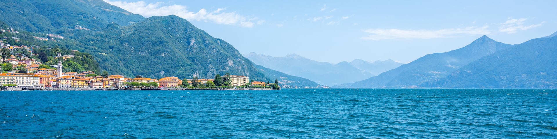 Visitors enjoy the serene beauty of Lake Como, surrounded by majestic mountains and charming villages. The clear blue waters reflect the vibrant landscape, evoking a sense of peace and relaxation.