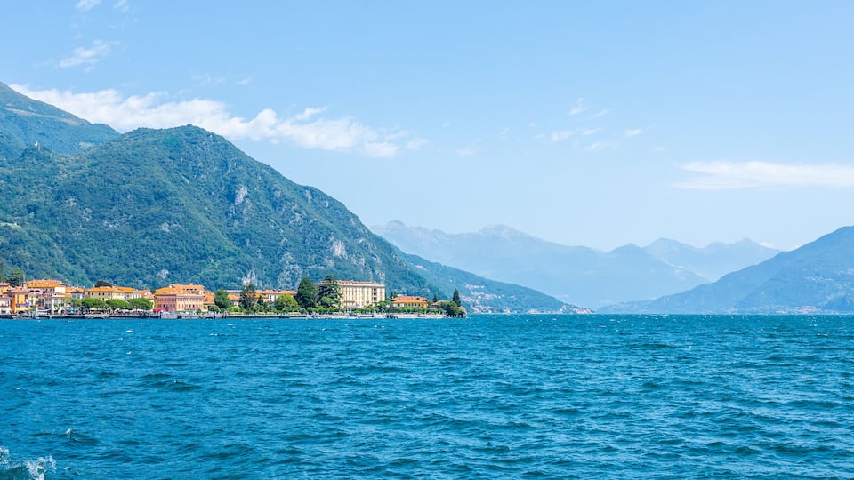 Visitors enjoy the serene beauty of Lake Como, surrounded by majestic mountains and charming villages. The clear blue waters reflect the vibrant landscape, evoking a sense of peace and relaxation.