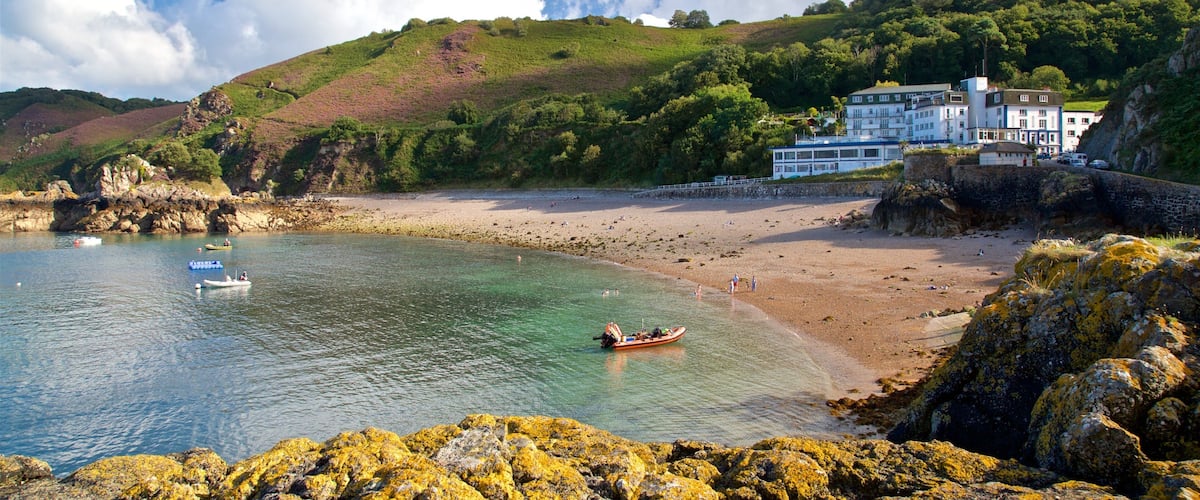 Bouley Bay showing a sandy beach, rocky coastline and a house