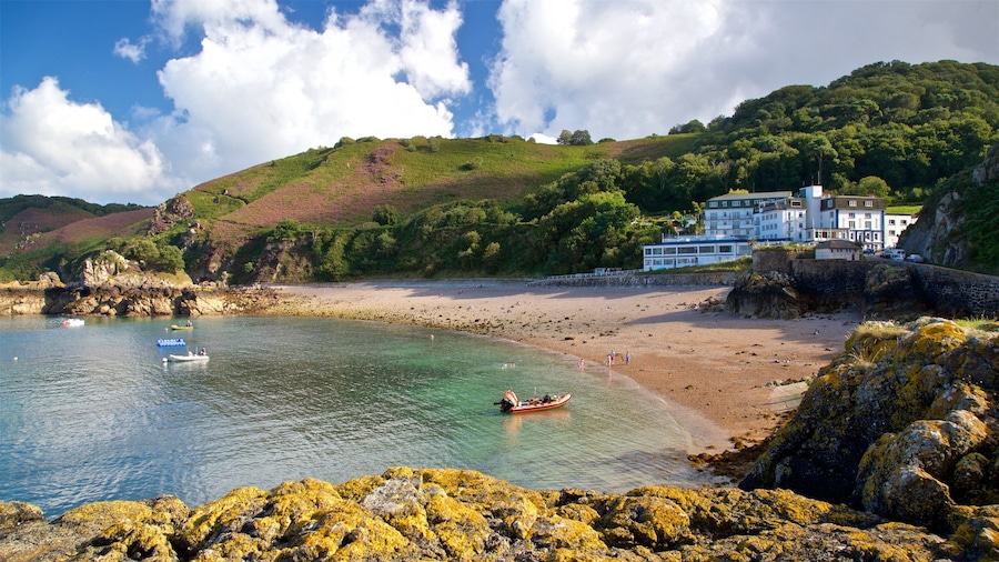 Bouley Bay showing a sandy beach, rocky coastline and a house