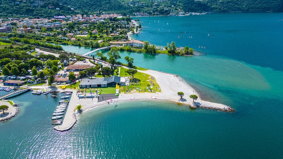 Drone view of northern Lake Garda near Torbole, Linfano. Surrounded by mountains, clear turquoise water, beaches, campings, and Monte Brione—perfect for nature, sport, and summer vacations
