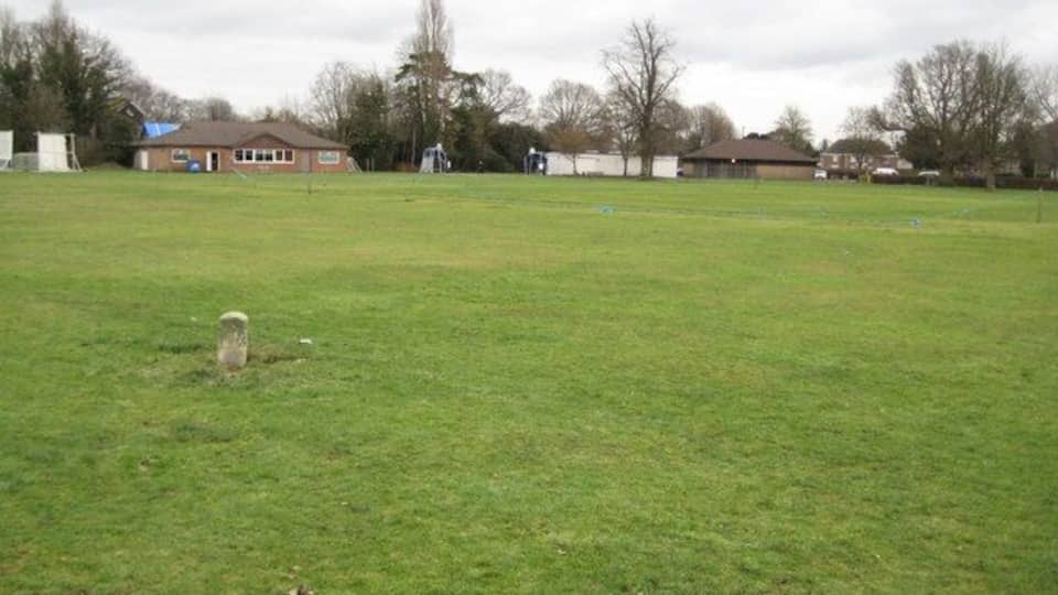 Ifield Green: Inclosure Boundary Stone This small boundary stone is the only surviving one from a group that were required to be placed on the village green under the terms of an Inclosure Award made in 1855. The award allowed inhabitants of the Parish of Ifield to use the area for exercise and recreation at all times of the year. The stone is in the outfield of the cricket pitch and is clearly visible on the satellite imagery of the "Where's the Path" website https://wtp2.appspot.com/wheresthepath.htm The co-ordinates are taken from that imagery. The cricket pavilion is in the background.