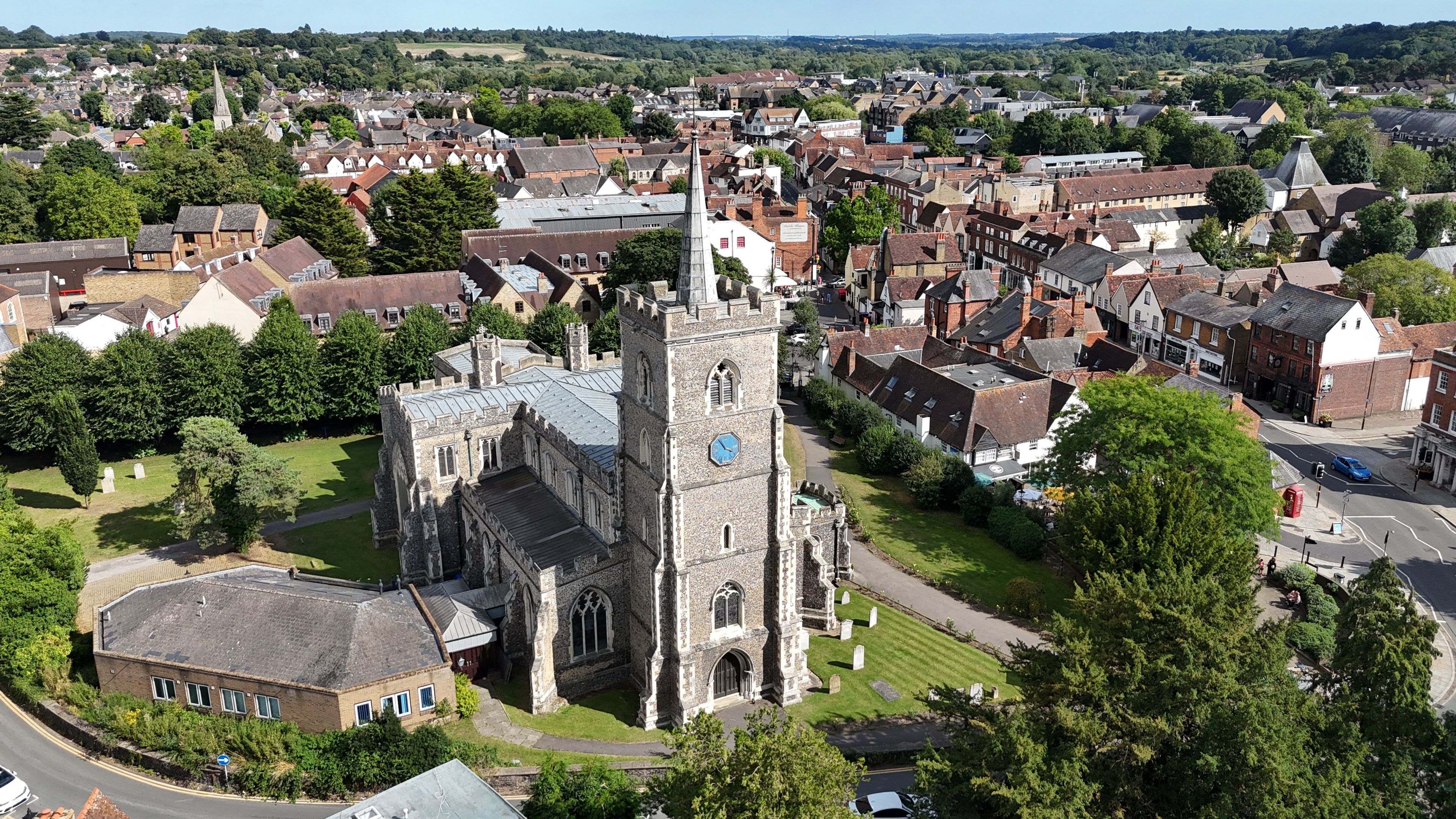 Une église historique dotée d’un clocher, entourée d’immeubles résidentiels et de verdure.