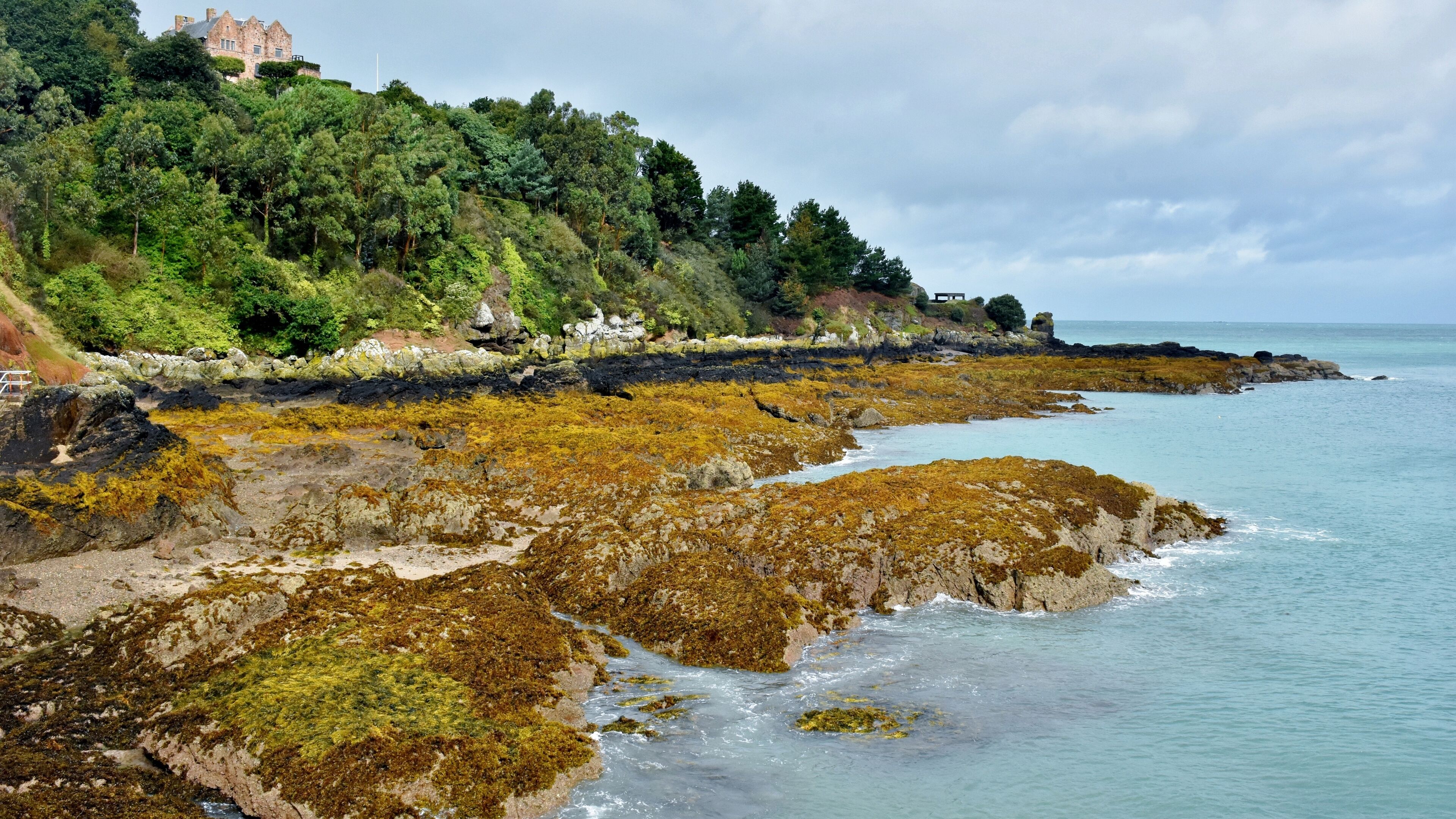 A small colourful picturesque bay and harbour in Jersey, When you walk along the harbour wall you will then have some wonderful views along the coast and back towards the small village 
