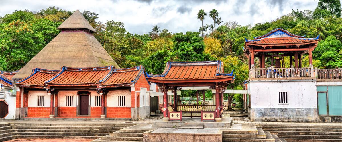 A traditional temple with a conical roof, a pavilion with a tiled roof, and a staircase leading up to the temple.