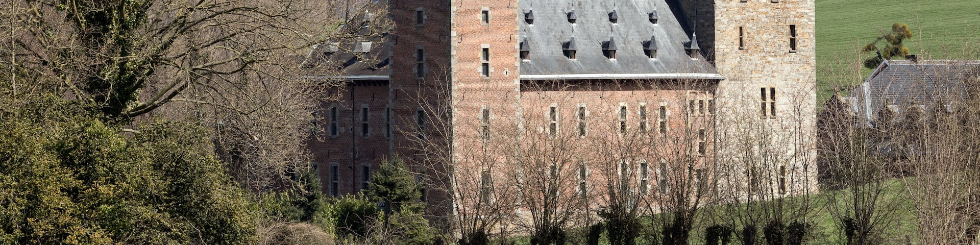 A historic castle with two prominent towers and a large brick building.