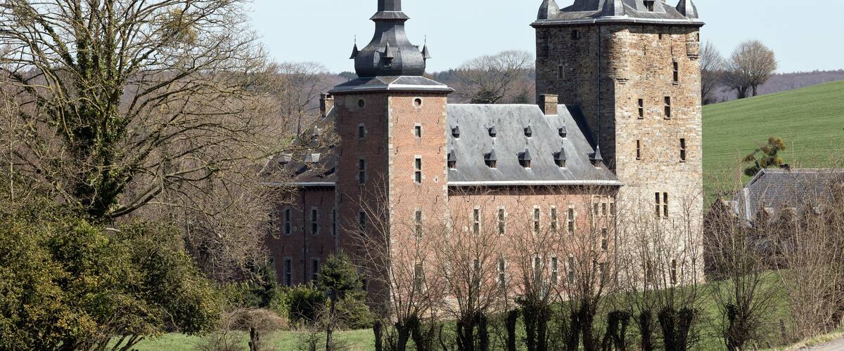 A historic castle with two prominent towers and a large brick building.