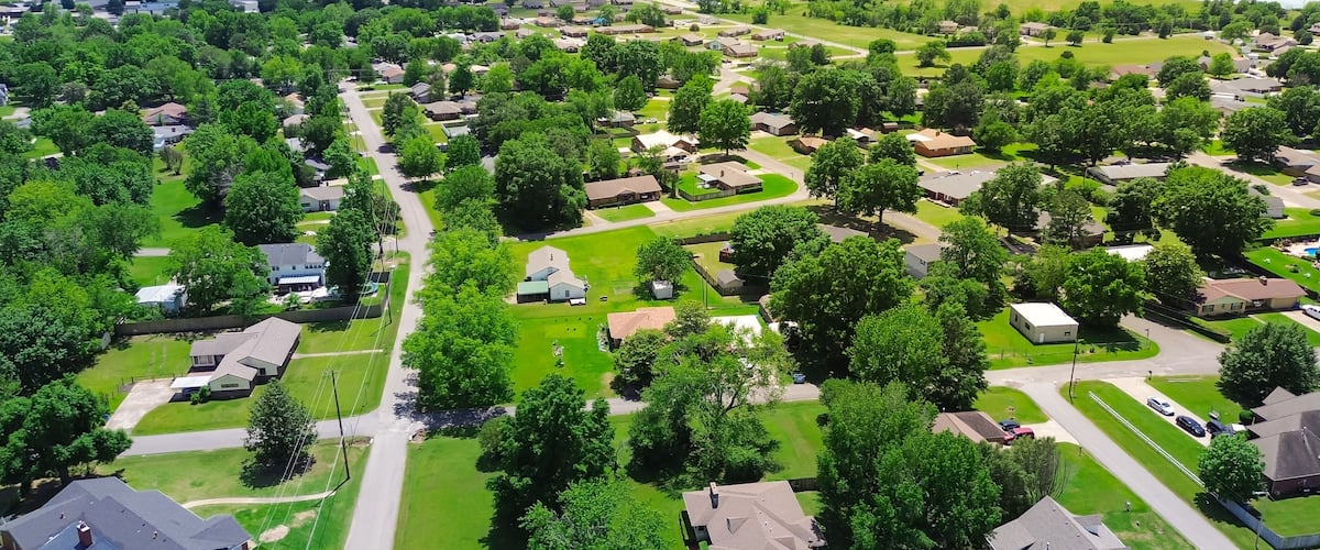 An aerial view of a residential area with houses, roads, and a large water tower.
