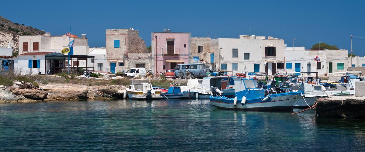 A coastal town with colorful buildings and boats docked at the harbor.