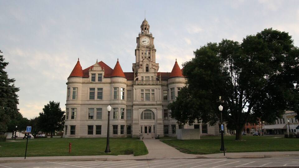 A large, historic building with a clock tower and red roofs.
