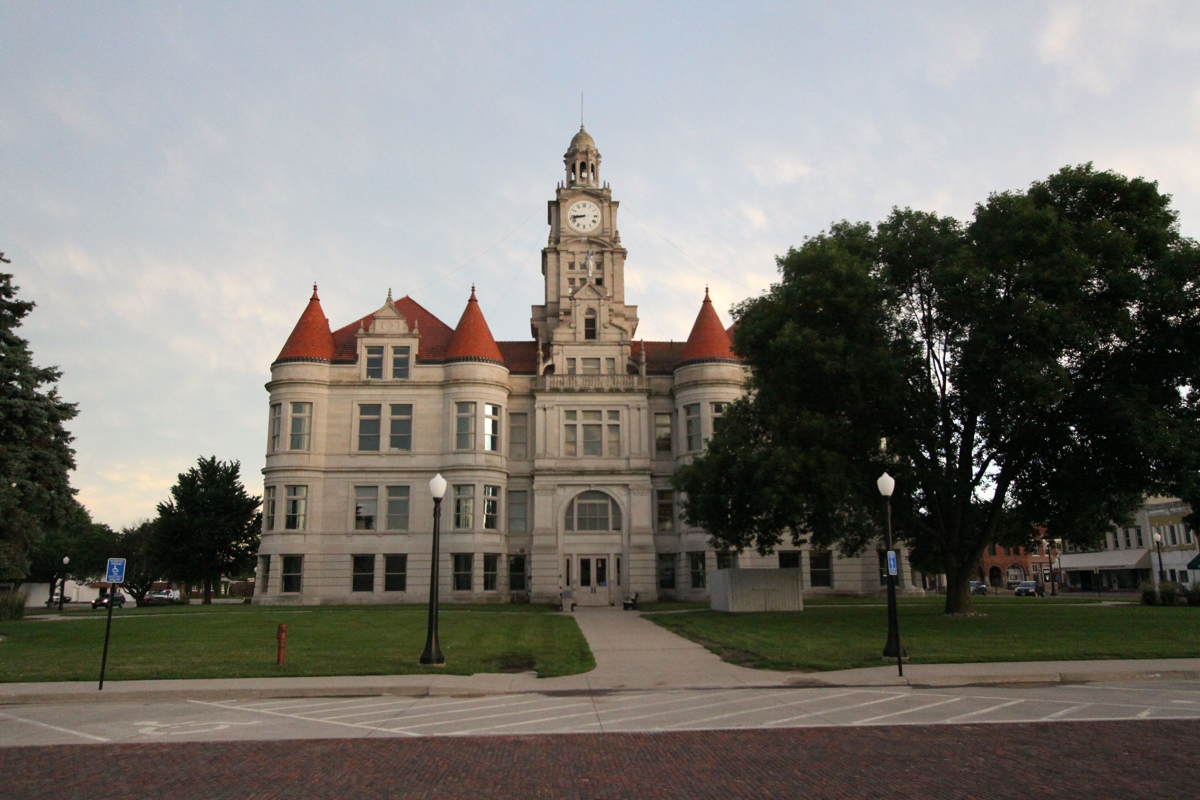 A large, historic building with a clock tower and red roofs.