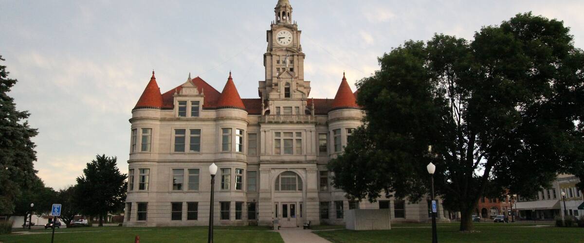 A large, historic building with a clock tower and red roofs.