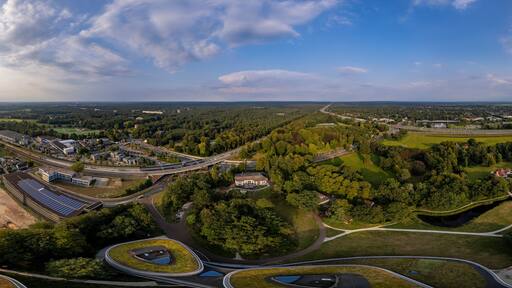 Super wide 180 degrees aerial panorama of Triodos bank in green park surrounding of Driebergen Zeist with train station and highway in the background