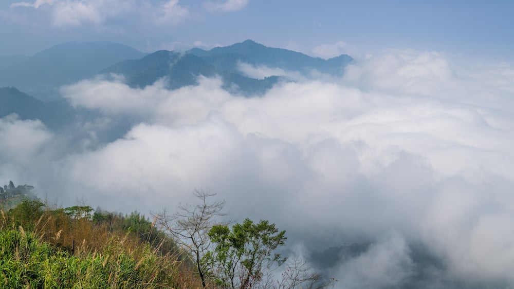 Ein Gebirge mit Wolken darunter.
