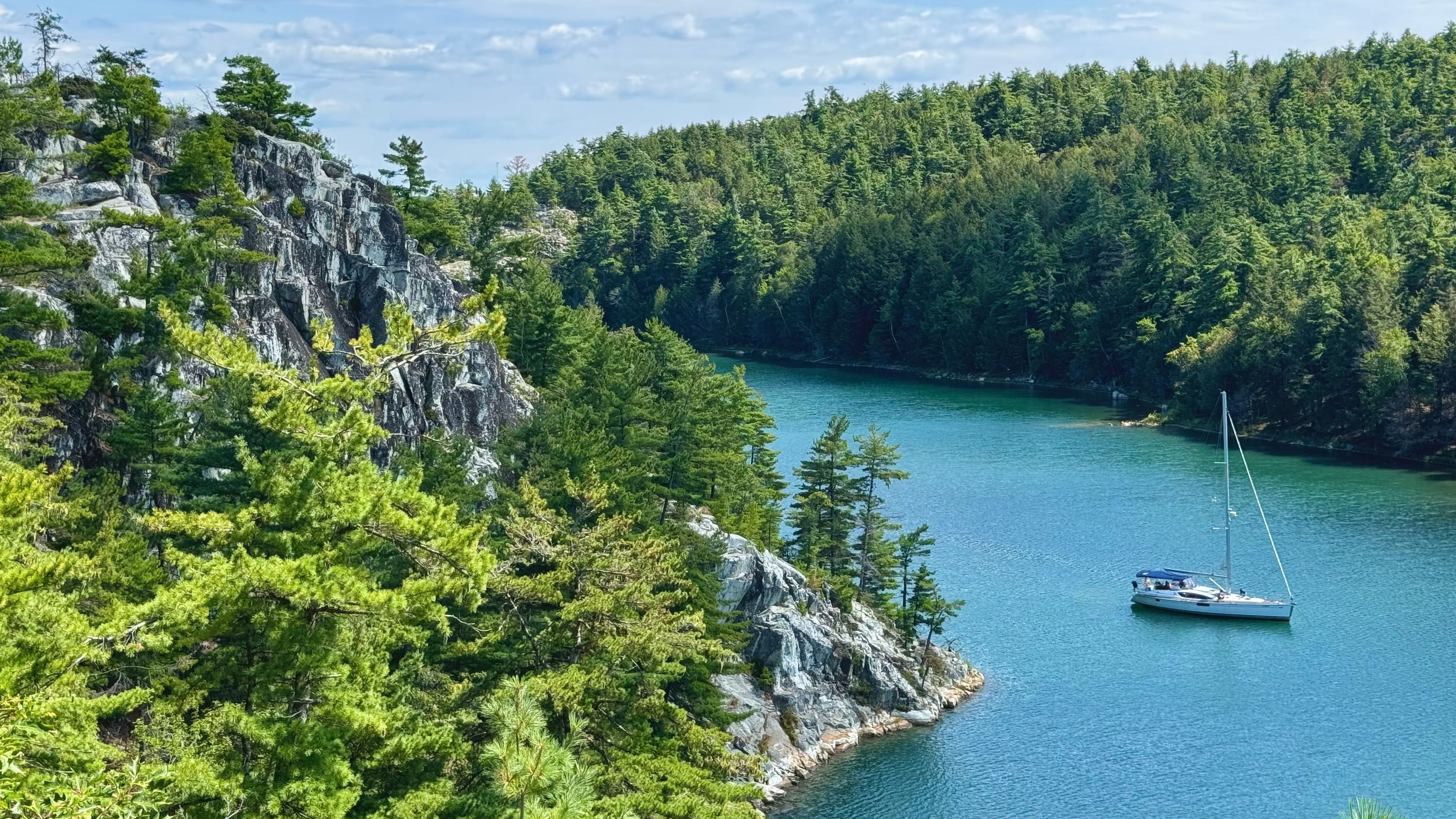 A lake surrounded by dense forest and rocky cliffs.