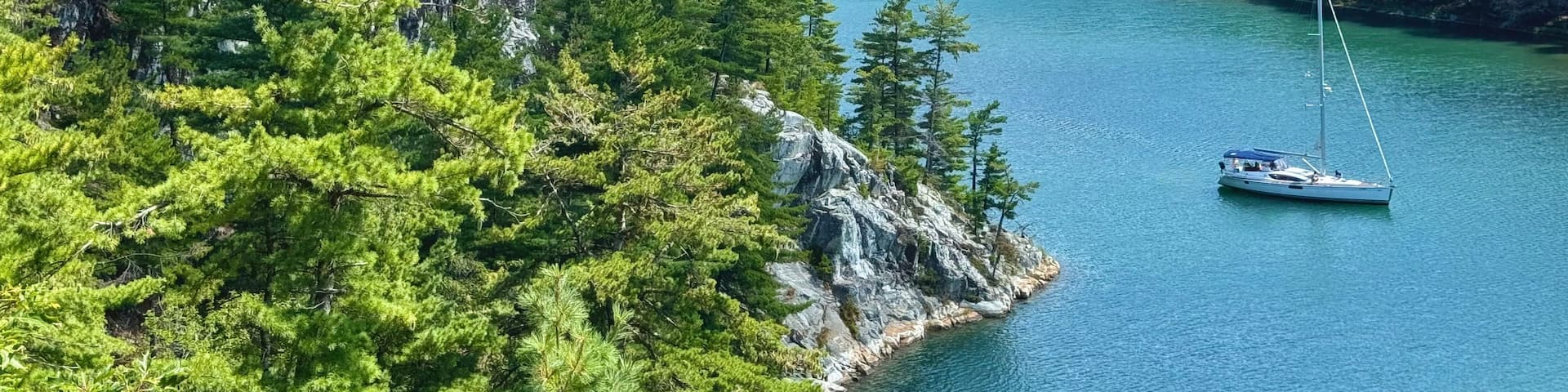 A lake surrounded by dense forest and rocky cliffs.