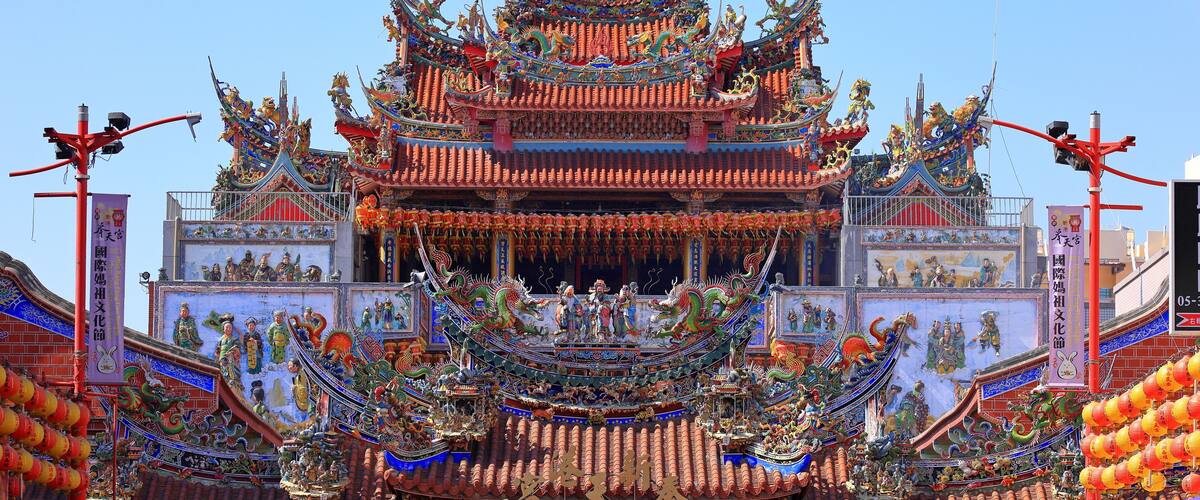 A traditional multi-tiered temple with ornate decorations and colorful dragons.