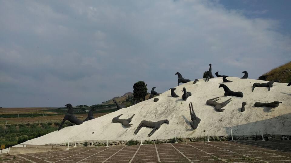 A large sculpture of animals on a hill.