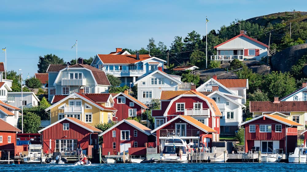 Colorful facades of Swedish summerhouse and sailing boats in harbour in archepelago of West coast Sweden, Bovallstrand by the Sea.