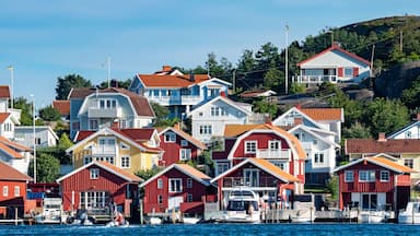 Uma vila costeira com casas coloridas, um cais e barcos.