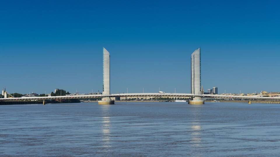 A bridge with two tall pillars over a body of water.