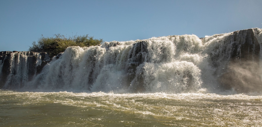 Travel and explore. Navigating the river. View of the Mocona falls from the boat in a summer sunny day.
