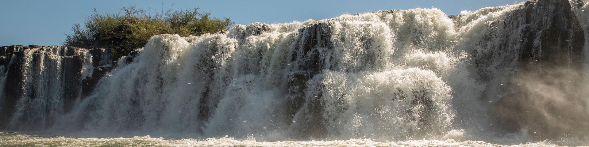 Travel and explore. Navigating the river. View of the Mocona falls from the boat in a summer sunny day.